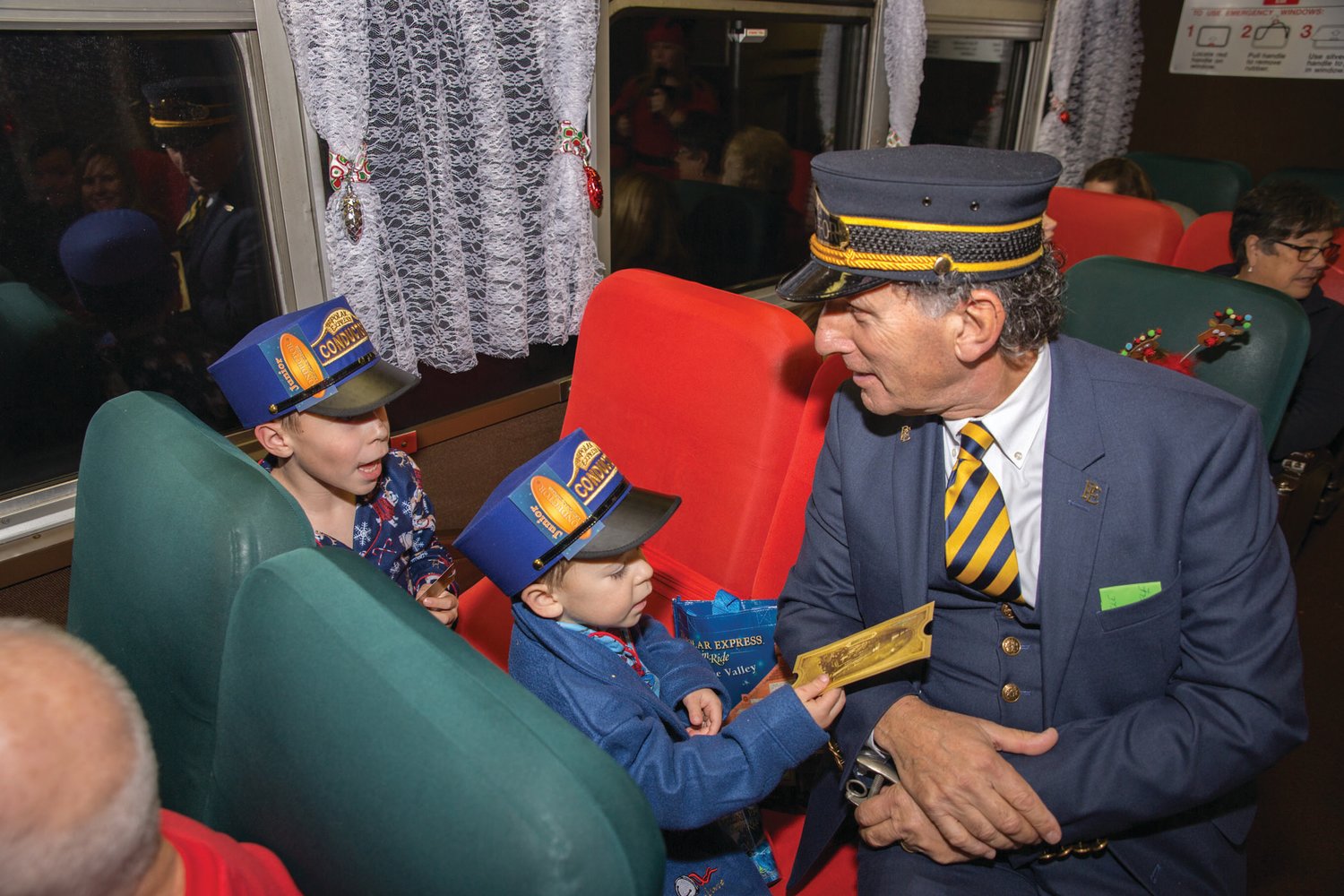 ALL ABOARD! Conductor Bob and junior conductors share a moment aboard the Blackstone Valley Polar Express Train Ride.